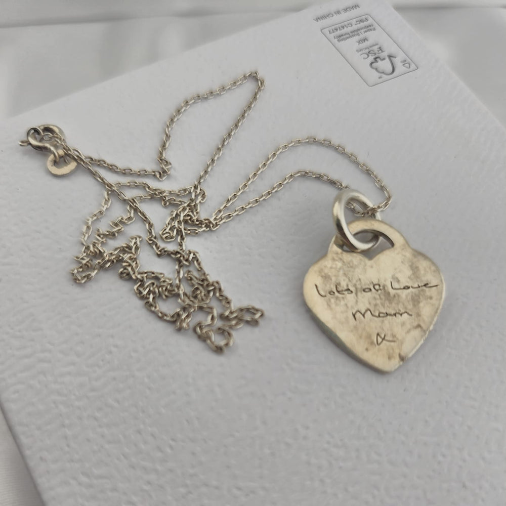 Silver heart pendant necklace engraved with a personal message, shown before professional cleaning and restoration by Tilly & Co Memorial Jewellery Ltd.