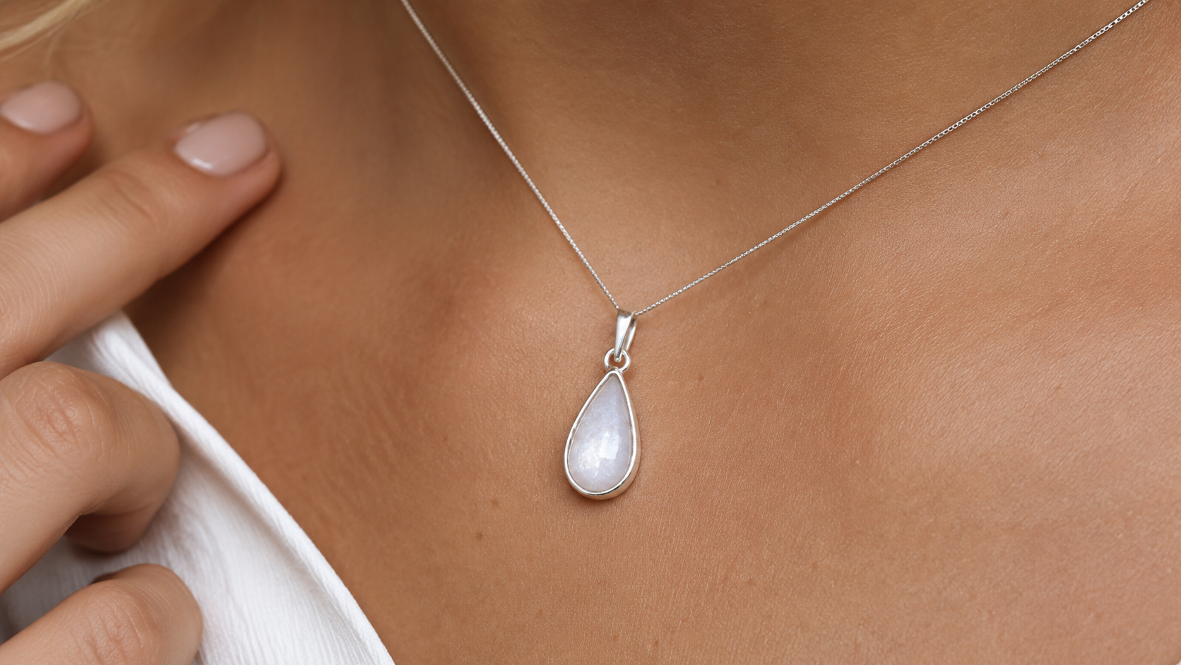 Tear of Love sterling silver memorial teardrop pendant worn at neckline.